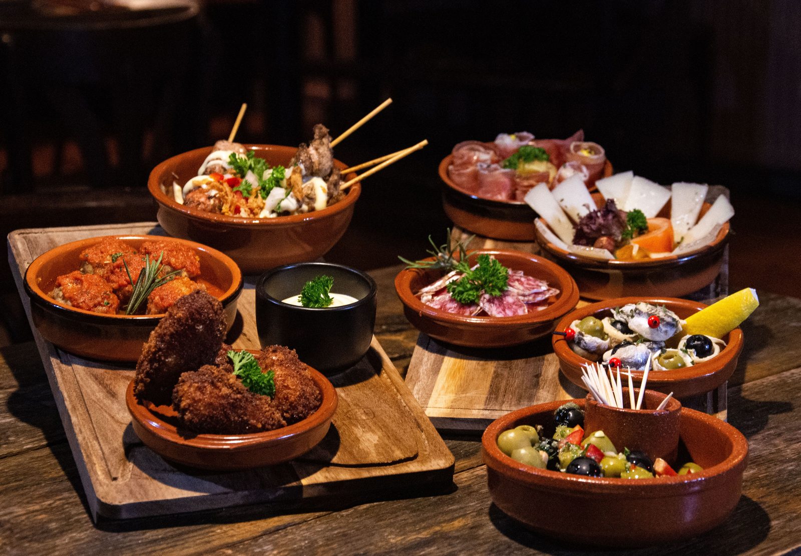 Mesa de tapas españolas en cazuelas de barro